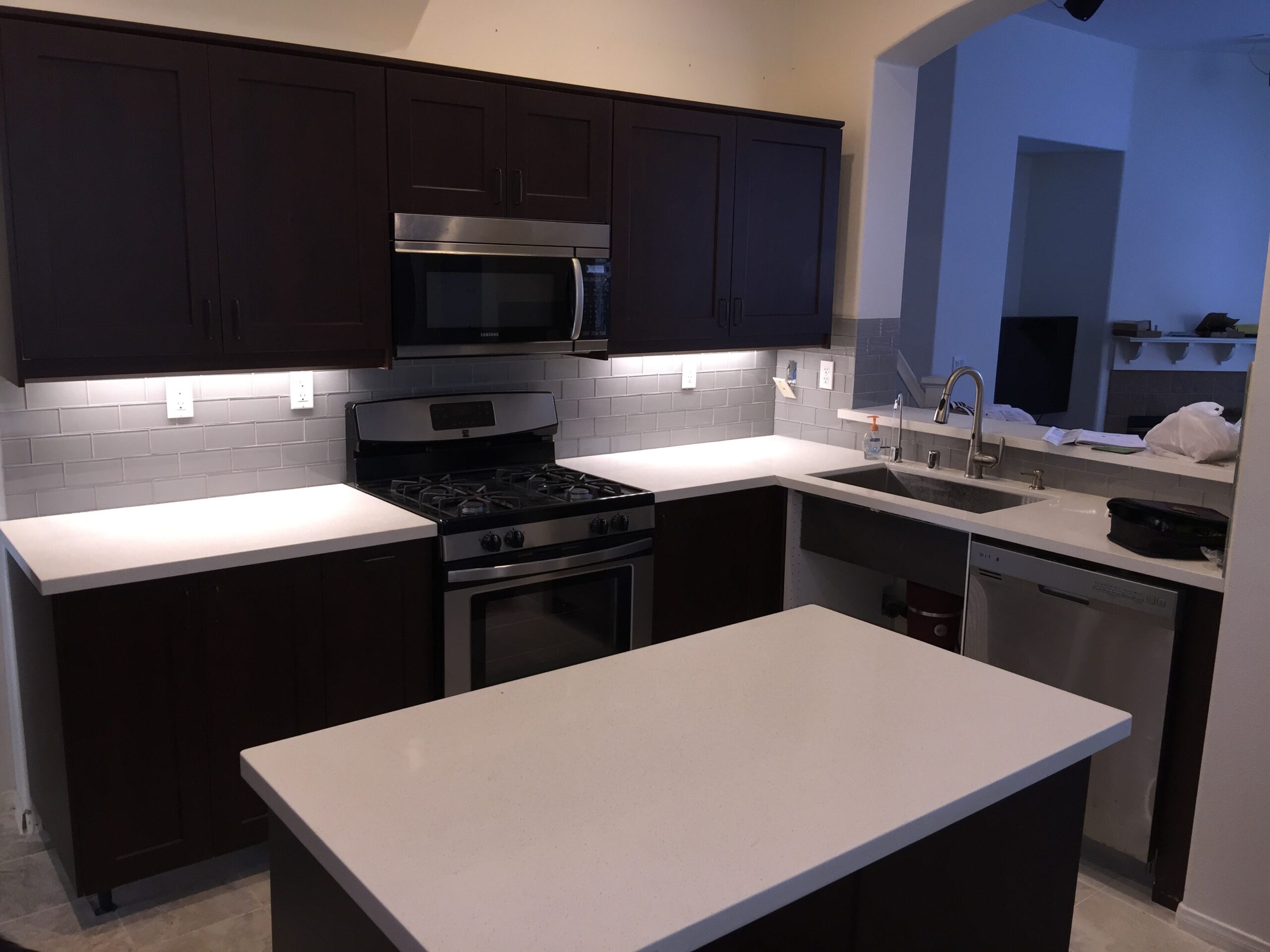 Kitchen Remodeling in San Marcos - CA crew installing new cabinets beside a covered island during renovation